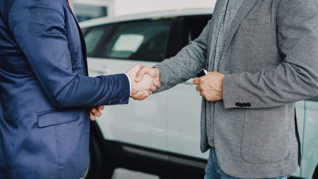 Business handshake in car dealership
